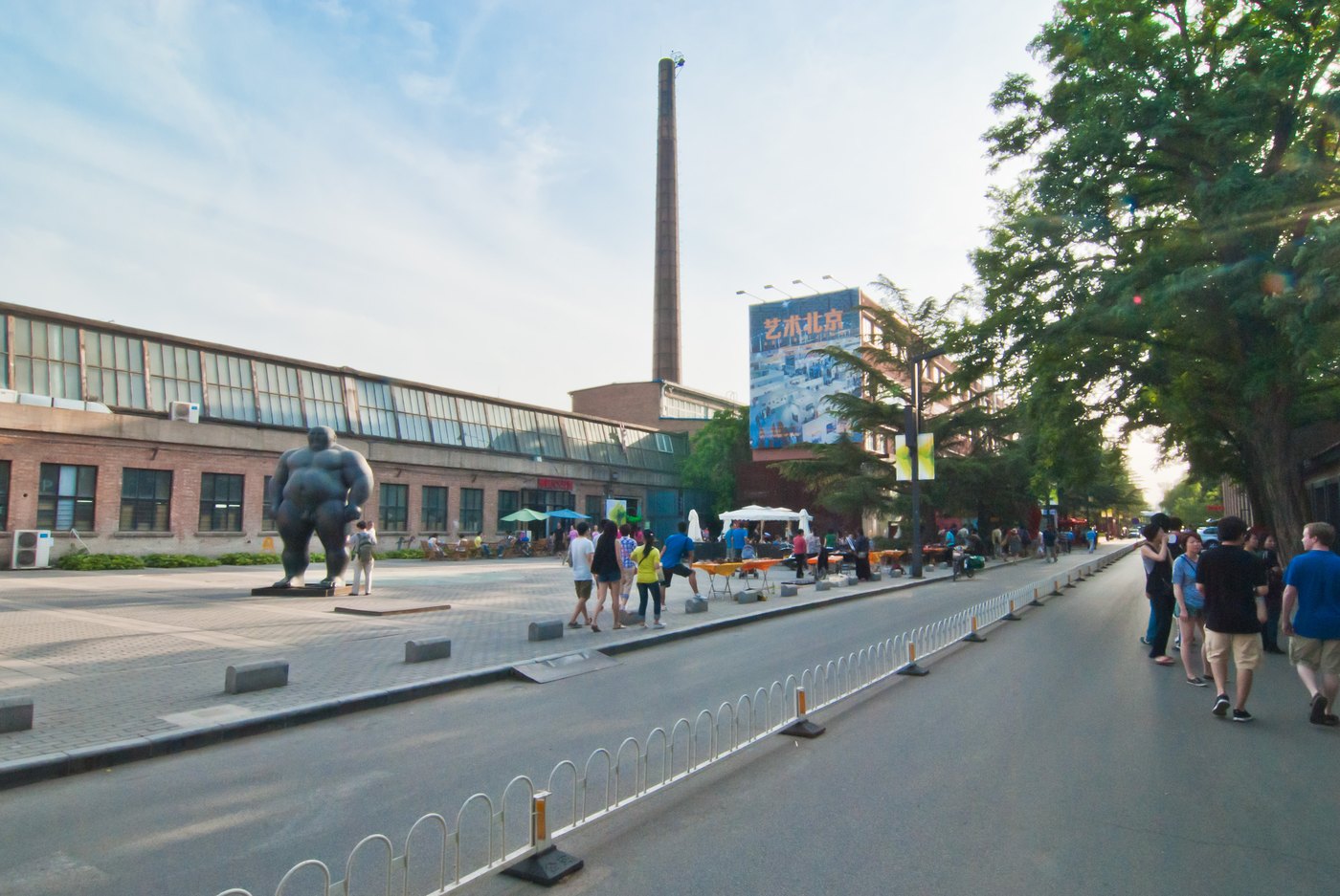 Calle del distrito artístico 798 de Pekín, con naves de ladrillo y la chimenea de la antigua fábrica